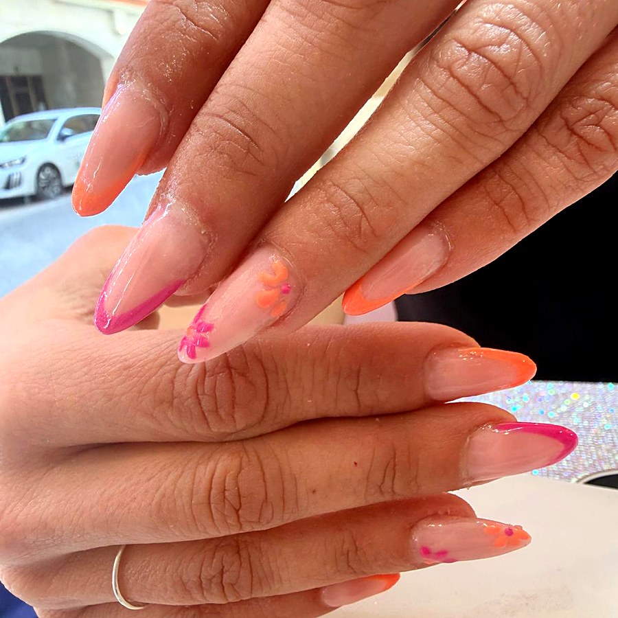 Manicura con detalles florales en naranja y fucsia
