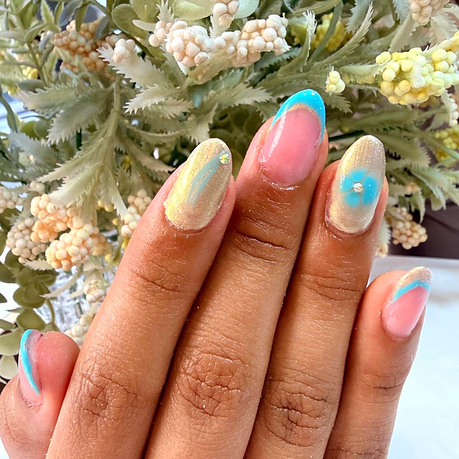 Manicura dorada con detalles florales en verde agua